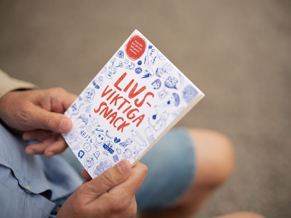 En person håller i boken Livsviktiga snack