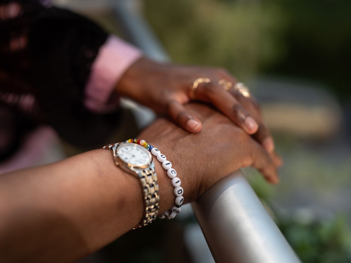 Händer som håller om varandra, en bär Suicide Zeros armband